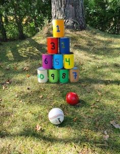 a stack of colorful blocks sitting next to a ball on top of a grass covered field