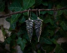 These fern earrings, adorned with moss agate charms, symbolise eternal growth and resilience. The fern, a classic emblem of lush forests, is paired with moss agate, known for its grounding properties and deep green hues. Together, they create a harmonious connection to the forest, evoking a sense of tranquillity and nature's enduring beauty. Wear these earrings to carry the forest's spirit and strength with you wherever you go. These enchanting earrings are suspended from secure earring hoops, making them perfect for everyday wear. The total length of each earring is approximately 7.5cm. This item is also available in other colour combinations in my shop.