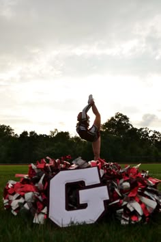 a cheerleader doing a handstand on top of a pile of tinsel