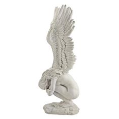 a statue of an angel kneeling down with its wings spread