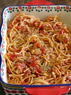 a red and white dish filled with pasta covered in tomato sauce, meat and cheese