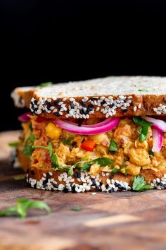 a sandwich with meat, vegetables and sesame seeds