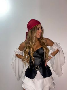 a woman dressed in a pirate costume posing for the camera with her hands on her hips