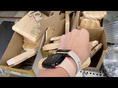 a person with a smart watch on their wrist in front of boxes and other items