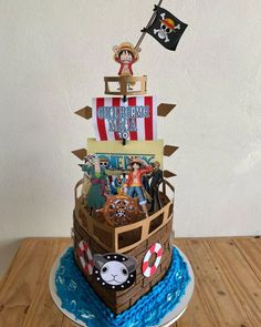 a cake made to look like a pirate's ship with pirates on board and other items