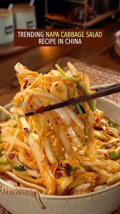 a bowl filled with noodles and vegetables on top of a table