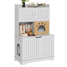 a white cabinet with a cat door and shelves on the top, next to a potted plant