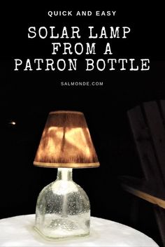 a glass bottle sitting on top of a table next to a lamp with the words solar lamp from a patron bottle