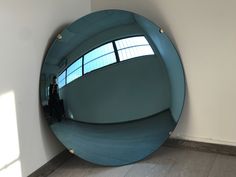 a large round mirror sitting on top of a wooden floor