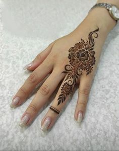 a woman's hand with henna tattoos on it