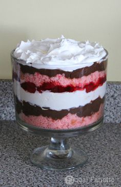 a layered cake with white frosting and raspberry filling on a glass pedestal