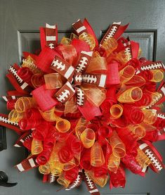 a football wreath is hanging on the front door, decorated with red and yellow ribbons