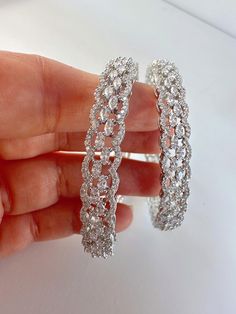 Silver Finish American Diamond/CZ Bangles/Bracelet/Indian Party Wear Bangles/ CZ stone bangles/Indian wedding/bridal jewelry Sold as a pair Opening :NOT Screw type Plating:- 18 K Silver plated CZ stone bangle Best gift option for your loved ones comes in an exquisite gift box. Dazzling Round Diamond Bracelet, White Gold Crystal Bangle Jewelry, Dazzling Hoop Jewelry For Wedding, Dazzling Silver Jewelry With Stone Work, Sparkling Hoop Jewelry For Wedding, White Gold Crystal Bangle, Crystal Hoop Jewelry For Weddings, Silver Round Jewelry With Stone Work, Wedding Bracelets With Sparkling Stones