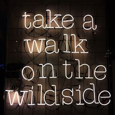 there is a neon sign that says take a walk on the wildside at night