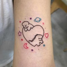 a small tattoo on the leg of a person with a teddy bear and planets in the background