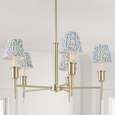 a chandelier with blue lamps hanging from it's sides in a living room