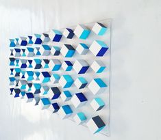 blue and white geometric shapes are hanging on the wall