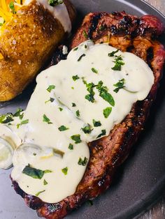 a plate topped with meat covered in white sauce