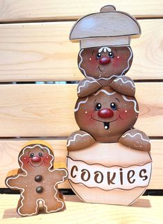 two gingerbread cookies stacked on top of each other in front of a wooden wall