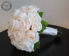 a bouquet of white roses on a black table