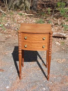 a small wooden table with three drawers