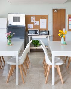 a kitchen with white table and chairs next to a microwave