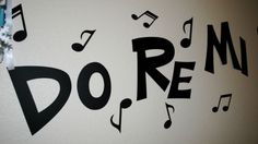 there is a wall with music notes on it and the word do re spelled in black