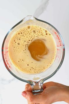 a hand holding a blender filled with liquid