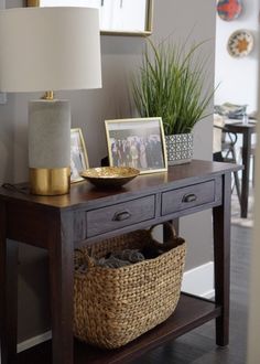 a wooden table with two baskets on top of it and a lamp next to it