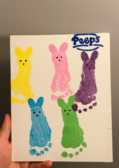 a hand holding up a piece of paper that has peeps on it in different colors