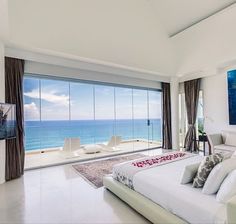 a large bedroom with an ocean view is shown in the foreground and on the far side