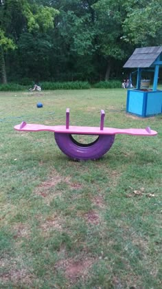 a purple object sitting on top of a lush green field next to a blue shed