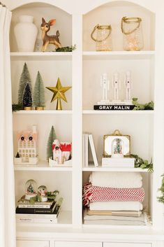 a white bookcase filled with christmas decorations