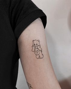 a small teddy bear tattoo on the arm