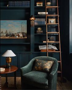 a living room filled with furniture and bookshelves next to a painting on the wall