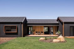 the house is made out of black corrugated and has two large windows on each side