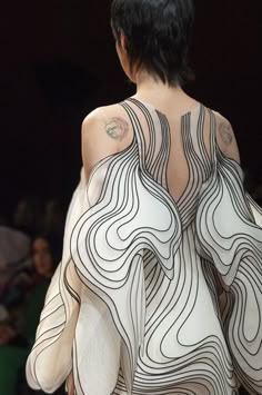 the back of a woman's white dress with black lines on it