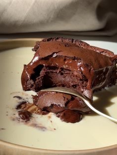 a piece of chocolate cake on a plate with a spoon