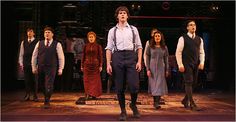 a group of people standing on top of a stage with one man in the middle