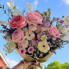 a bouquet of pink and white flowers on top of a metal pole with blue sky in the background