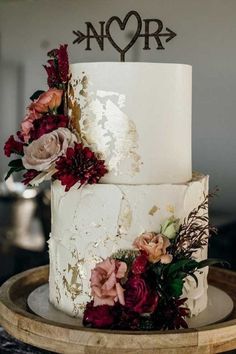 a three tiered wedding cake with flowers on top