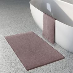 a bath tub sitting next to a rug on the floor