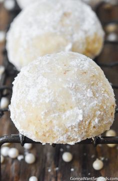 three powdered sugar donuts on a wire rack