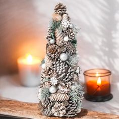 a small pine cone christmas tree sitting next to a candle