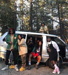 four people standing in the back of a van