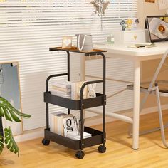 a desk with a computer on top of it next to a chair and potted plant