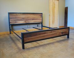 a wooden bed frame sitting on top of a hard wood floor next to a wall