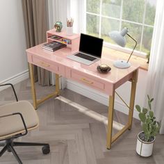 a computer desk with a laptop on top of it next to a chair and potted plant