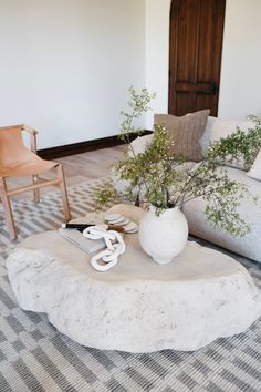 a living room with a couch, chair and coffee table in front of a door