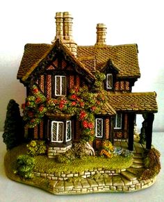 a figurine of a house with flowers on it